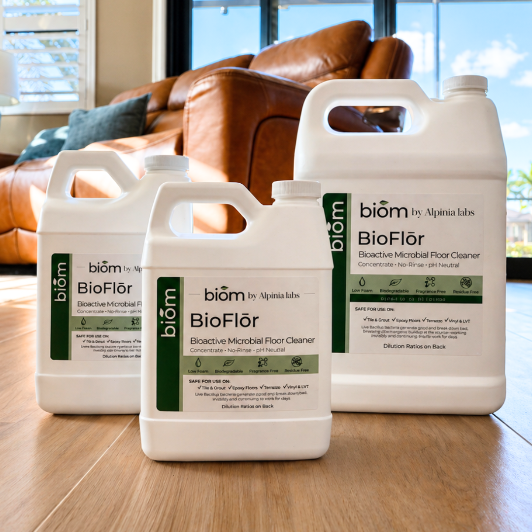 Three bottles of biom BioFlor floor cleaner on a wooden floor with a couch in the background.